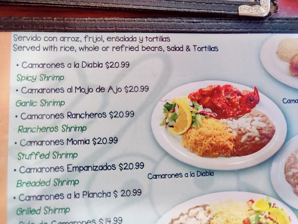 Plates of seafood and tacos on a casual table.