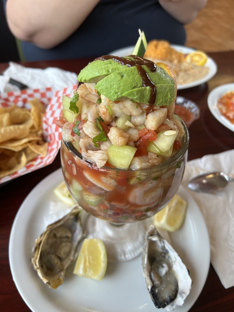 Plates of seafood and tacos on a casual table.